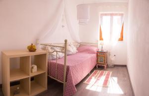 een slaapkamer met een bed met roze lakens en een raam bij Apartment Dore in Krk