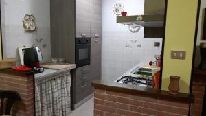 kuchnia ze zlewem i kuchenką w obiekcie B&B La villetta rossa w Anzio