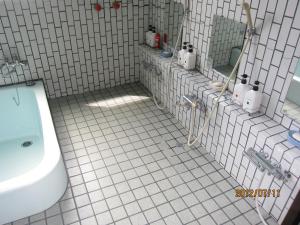 a white tiled bathroom with a toilet and a sink at Lake Oshino in Oshino +40 photos
