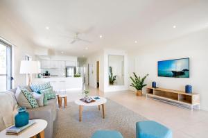 a living room with a couch and a table at 53 Hilton Esplanade, Tewantin in Noosaville