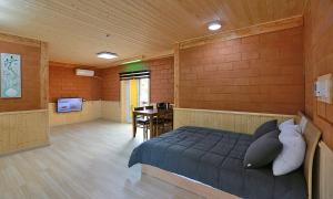 a bedroom with a bed and a table in a room at Rainbow Hwangto Pension in Pyeongchang