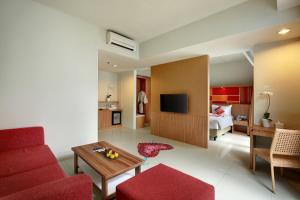 sala de estar con sofá rojo y TV en Kyriad Hotel Airport Jakarta en Tangerang