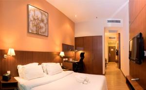 um quarto de hotel com uma cama com um bicho de peluche em Swiss Hotel Apartment em Kuala Belait