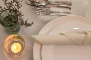a table with a candle and a white plate and a candle at Swiss Hotel Apartment in Kuala Belait