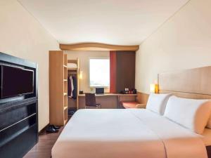 泗水的住宿－泗水市中心宜必思酒店，酒店客房设有一张大床和一台电视。
