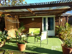 a patio with a pergola and two chairs and a table at Les Aubepines in La Plaine des Palmistes