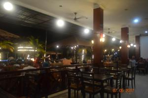 a restaurant with people sitting at tables at night at Virgo Batik Resort in Lumut