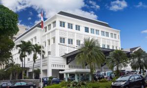 un edificio bianco con auto parcheggiate di fronte di The Mirah Hotel Bogor a Bogor