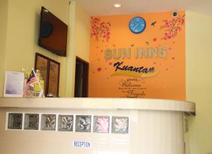 a sign for the sun inn kalamazoo with a clock at Sun Inns Rest House Kuantan in Kuantan