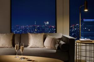 a living room with a couch and two glasses of wine at Keio Plaza Hotel Tokyo Premier Grand in Tokyo