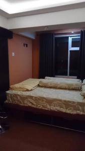 a bedroom with two beds and a window at Jarrdin Cihampelas C2218 in Bandung