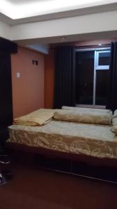 Un dormitorio con dos camas y una ventana. en Jarrdin Cihampelas C2218, en Bandung