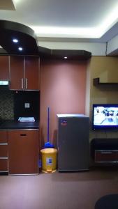 a kitchen with a small refrigerator and a tv at Jarrdin Cihampelas C2218 in Bandung