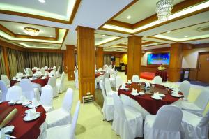 a banquet hall with white tables and white chairs at Chiangmai S.P. Hotel in Chiang Mai