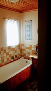 La salle de bains est pourvue d'une baignoire et d'une fenêtre. dans l'établissement Athanor Cottages, à Hogsback