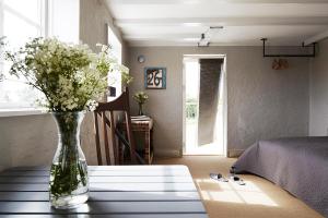 a vase of flowers on a table in a bedroom at Gotland Magazin1 Guesthouse in Havdhem