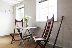 a table with two chairs and a vase of flowers at Gotland Magazin1 Guesthouse in Havdhem