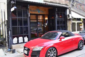 a red car parked in front of a building at Double Five in Bangkok