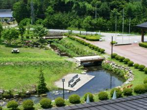 a park with benches and a pond and a bridge at Komao in Kiso