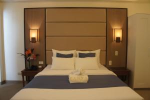 a bedroom with a large bed with a large headboard at Panja Resort Palawan in Puerto Princesa City