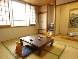 a living room with a table and a chair at Komao in Kiso