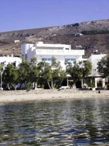 a large white building next to a body of water at Hotel Paros in Parikia