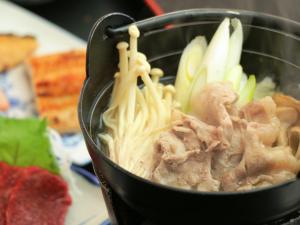 a pot filled with noodles and meat and vegetables at Komao in Kiso
