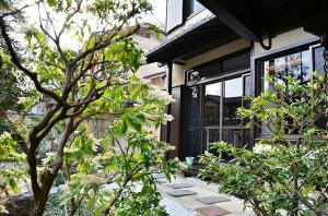 una casa con un árbol delante de ella en Kinkaku en Kioto