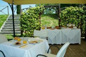 two tables with plates of food sitting under an umbrella at Agriturismo Le Colombe Assisi in Assisi