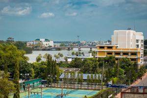 a building with a tennis court next to a river at Pongkaew Hotel in Suratthani