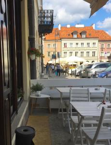 a balcony with tables and chairs on a city street at Oki Doki OLD TOWN in Warsaw