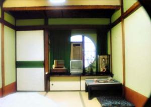 a room with a room with a table and a mirror at Tama Ryokan in Tokyo