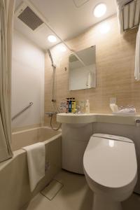 a bathroom with a toilet and a sink and a tub at Belken Hotel Tokyo in Tokyo