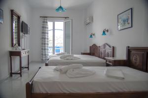 a bedroom with two beds with towels on them at Erato Apartments in Batsi