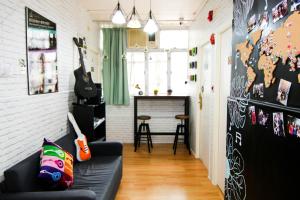 a living room with a couch and a guitar at Cozy Inn Jordan Station in Hong Kong