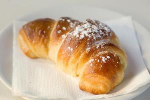 two croissants sitting on a napkin on a plate at La Valle Verde hotel ristorante pizzeria in Zambrone
