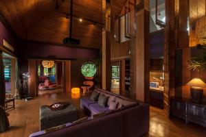 a living room with a purple couch and wooden walls at Chandra Residence in Chiang Mai