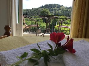 a flower on a bed with a view of a balcony at Filoxenia Kontogiannis in Lazaráta