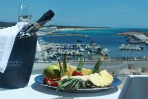 un piatto di cibo su un tavolo con un bicchiere di vino di Nauticus Guest Room a Torre San Giovanni Ugento