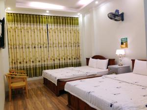 a hotel room with two beds and a window at Ninh Binh Central Hotel in Ninh Binh