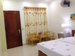 a bedroom with a bed and a table and chairs at Ninh Binh Central Hotel in Ninh Binh