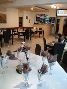 a table in a restaurant with tables and chairs at Pensiune Restaurant Sfinx in Buşteni +7 photos