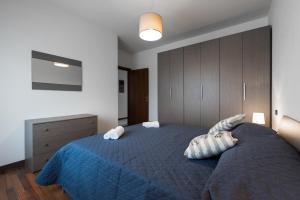 a bedroom with a blue bed with two pillows at Ortaglia B2 in Torri del Benaco