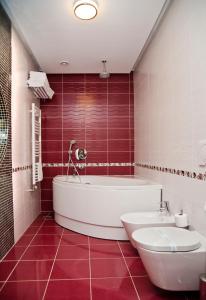 uma casa de banho com uma banheira, um WC e um lavatório. em Hotel President em Baile Felix