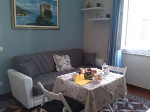 un soggiorno con tavolo e divano di Profumo di casa a La Spezia