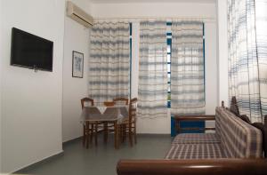 a living room with a table and chairs and a television at Erato Apartments in Batsi