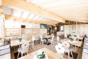 ロデンゴにあるAhner Berghofの木製の壁とテーブルと椅子が備わるレストラン