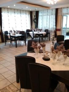 a dining room with tables and chairs and windows at Pensiune Restaurant Sfinx in Buşteni