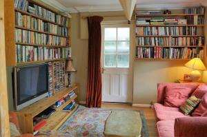 a living room with a tv and books at Inkerman in Lavant