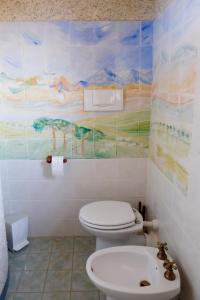 baño con aseo y una pintura en la pared en Casa Felice, en Passo Corese